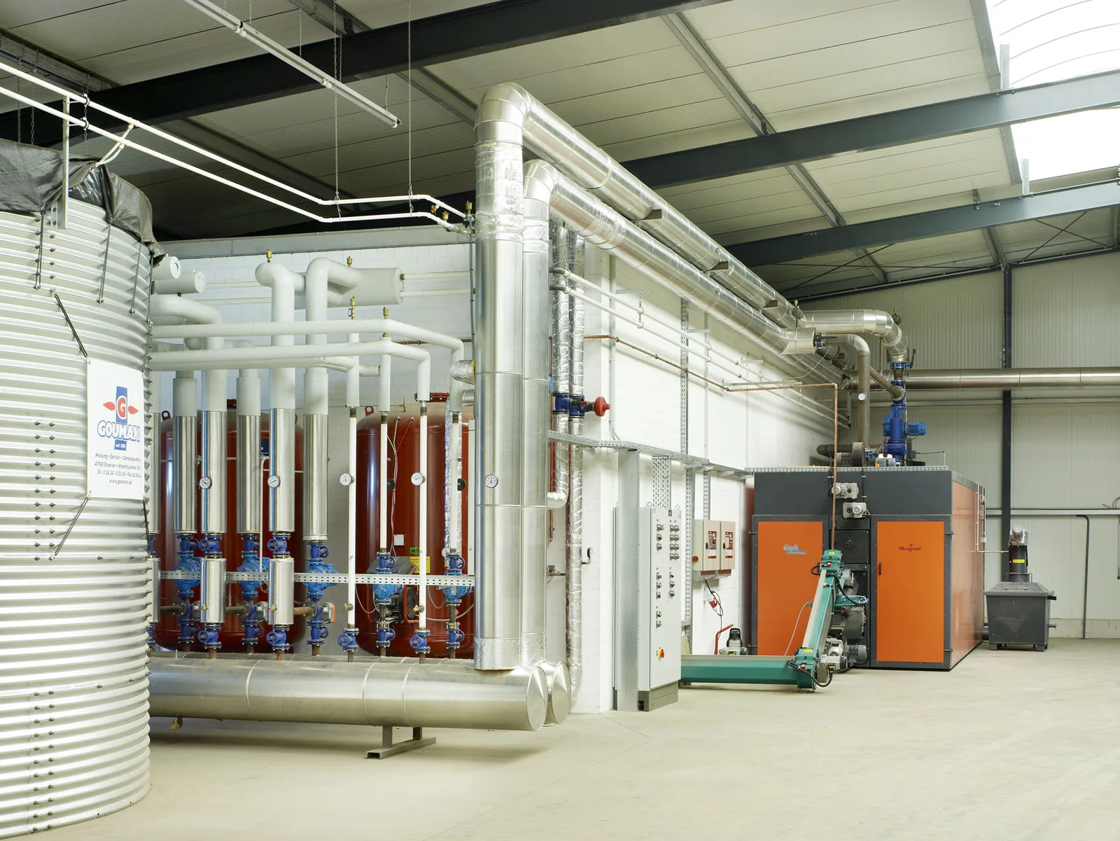 Heizzentrale mit Verteiler und Pumpen in einer Halle